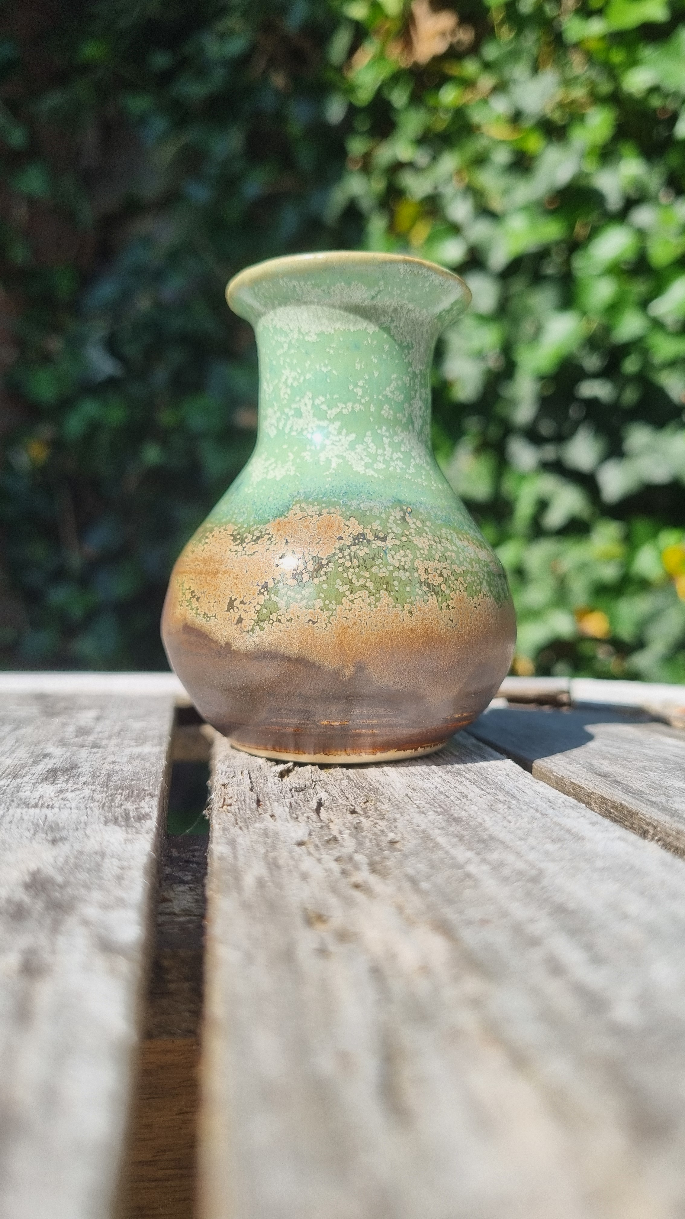 Handgemaakte keramische vaas door Mira met groen en bruin gespikkeld glazuur en sierlijke hals